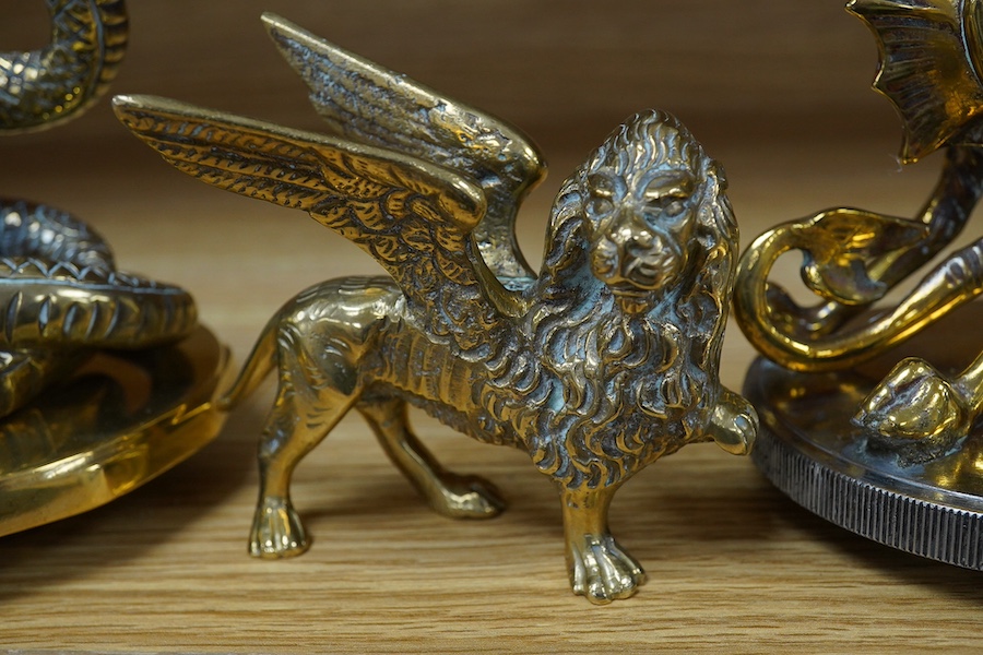 Three brass radiator mascots; one of a coiled snake, one of a dragon, and a winged lion, tallest 18cm. Condition - fair to good.